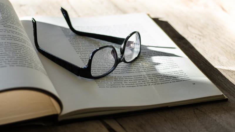 Reading glasses resting on an open book